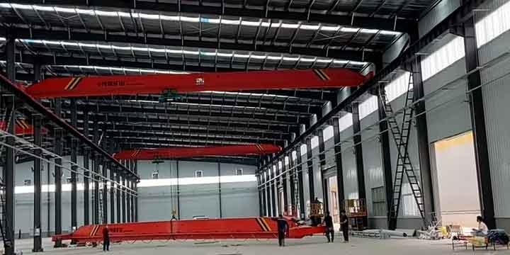 Nave industrial equipada con puentes grúa rojos instalada por un proveedor de estructuras de acero certificado