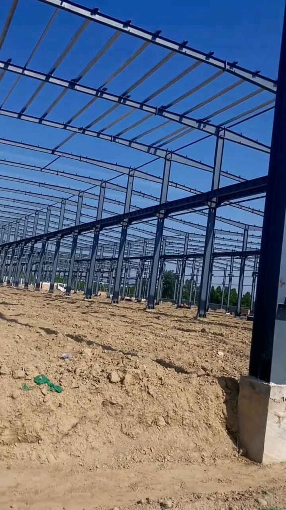 Detalle de pilares de acero H y bases de cimentación instalados por un proveedor de galpones industriales prefabricados.