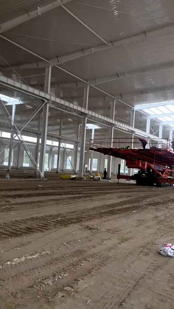 Interior de una nave de gran escala en proceso de techado por un steel building manufacturer líder en el sector.
