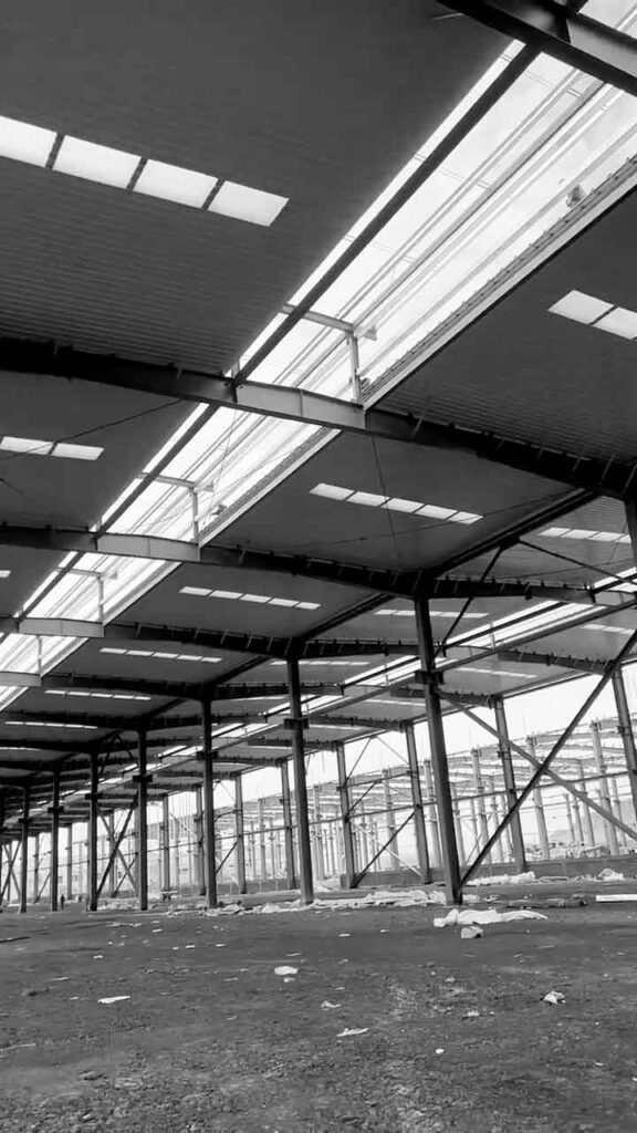 Interior despejado de un warehouse prefabricado con múltiples bahías para carga y descarga logística.