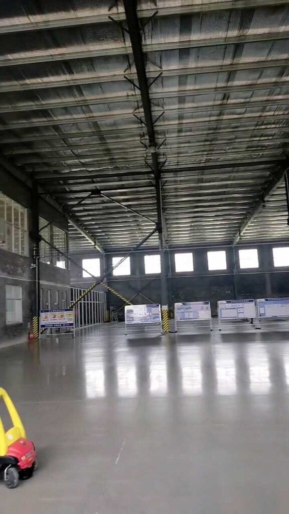 Massive clear span warehouse interior featuring polished grey industrial floors and fully insulated steel roof panels.