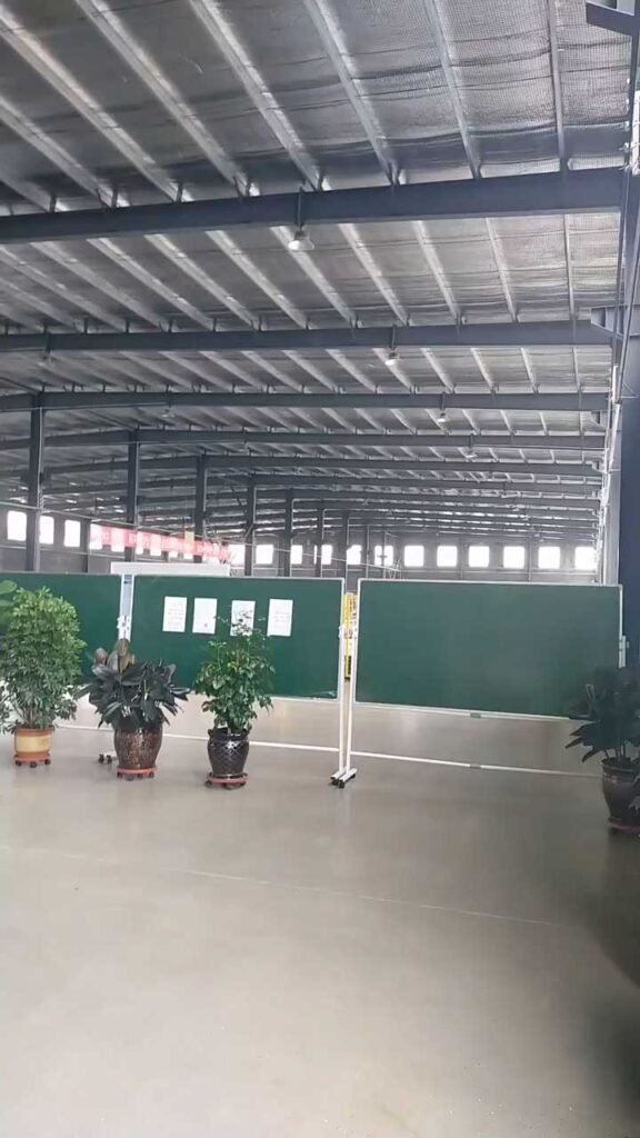Wide open column free warehouse floor showing flexible space usage with temporary room dividers and potted plant decor.