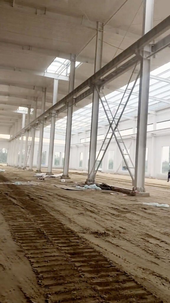 Interior of a column free warehouse showing the structural X-bracing and a massive open-plan layout for flexible inventory management.
