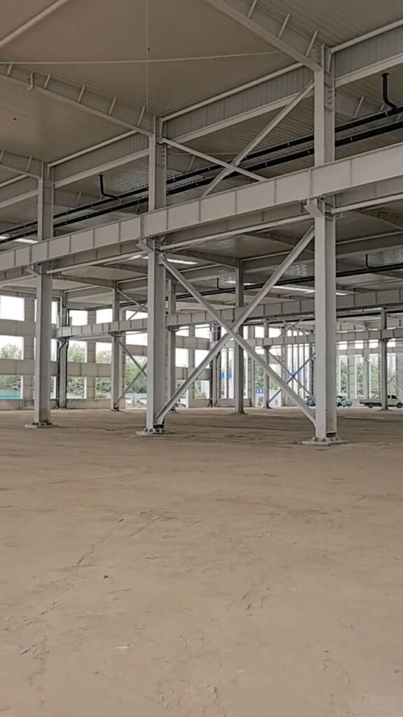 Perspectiva interior que muestra el diseño de una bodega moderna con franjas de luz natural cenital y esqueleto de acero