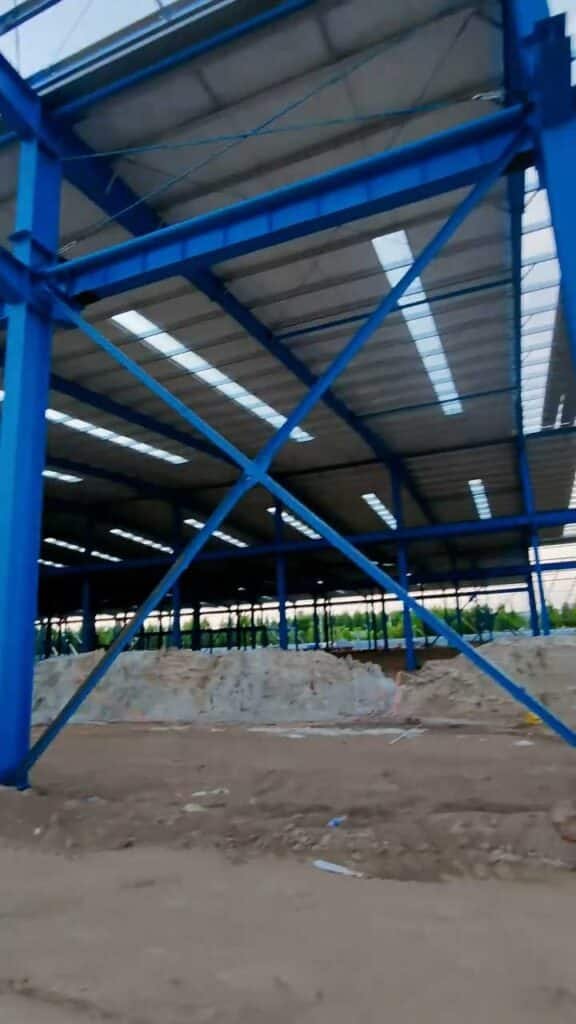 Close-up of seismic-resistant X-bracing and heavy-duty steel columns in an industrial project design for a supply chain warehouse.