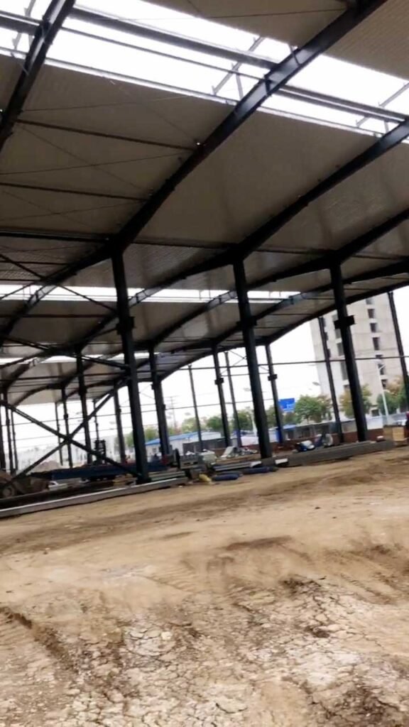 Interior roof perspective highlighting industrial steel standards for purlin spacing and rigid-frame rafter connections.
