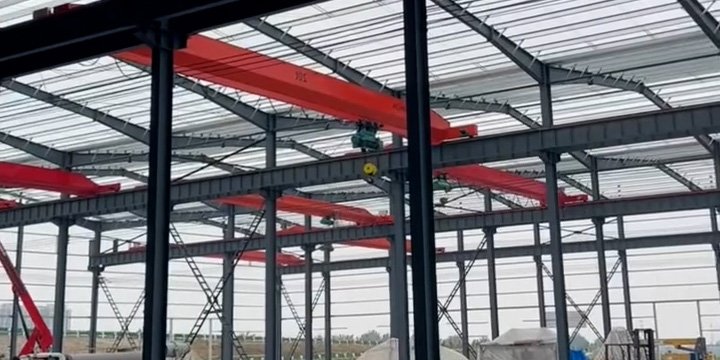 Proyecto de nave industrial en México equipado con múltiples puentes grúa rojos para manufactura pesada.