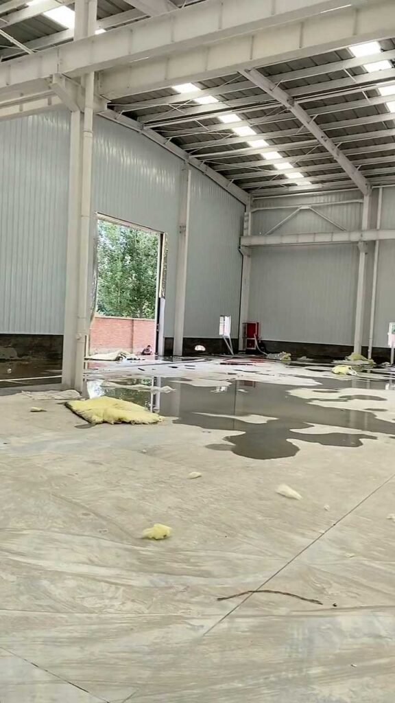 Interior de bodega con marcos rígidos de acero y sistema de drenaje pluvial integrado en la estructura.