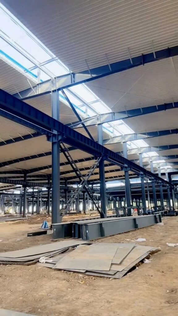 Almacén industrial en construcción con lucernarios para ahorro energético, suministrado por experto en acero industrial.