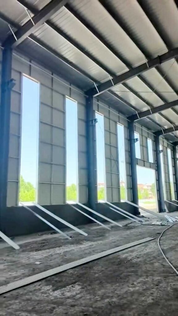 Perfiles de acero y vigas de un modular steel building depositados en el suelo de una obra de gran escala.