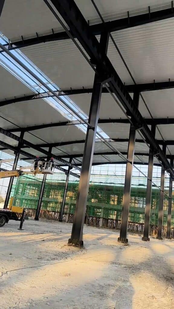 Montaje de estructura metálica industrial con grúa, construcción de nave metálica.