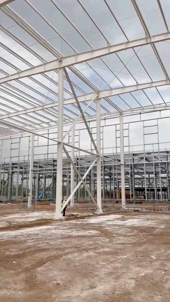 Interior de un PEB warehouse de gran luz con techumbre blanca aislante y vigas de acero de alta resistencia.