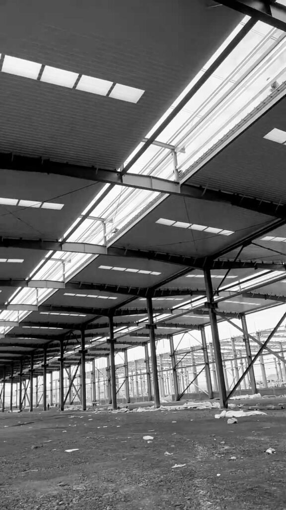 Techumbre de un prefabricated steel warehouse con paneles aislantes y franjas de luz natural integradas.