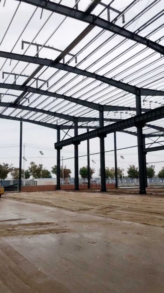 Massive warehouse frame demonstrating steel building compliance with US building codes and high-strength H-beam column alignment.