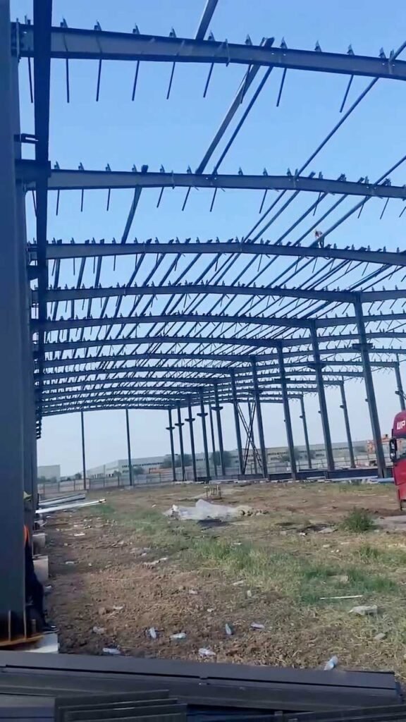 Internal perspective showing the grid of roof purlins and rafters in a large-scale steel structure warehouse