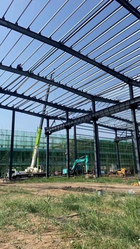 Vista lateral de una nave en construcción producida por nuestra steel structure factory con capacidad de exportación a toda Latinoamérica.