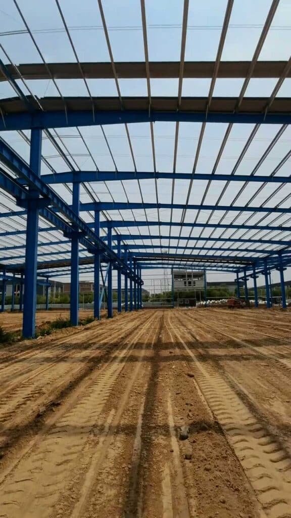 Vista de pasillos centrales de un warehouse for supply chain en construcción con simetría estructural perfecta.
