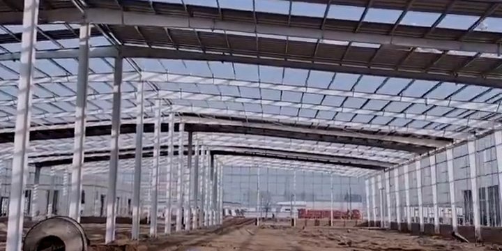 Wide perspective of a complete warehouse building solution under construction, demonstrating efficient load distribution across multiple clear-span structural bays.