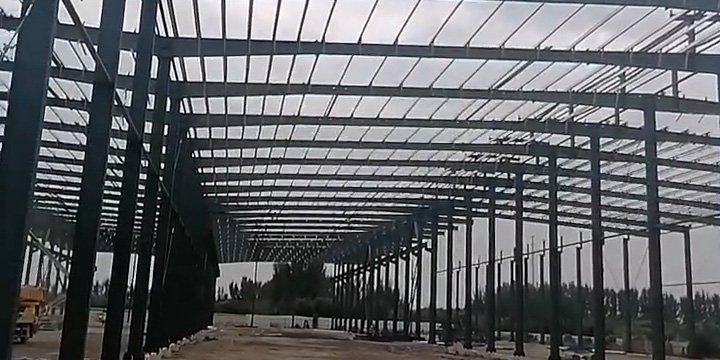 Massive multi-span FOB prefabricated steel building under construction, demonstrating extensive structural engineering and large-scale manufacturing capabilities.