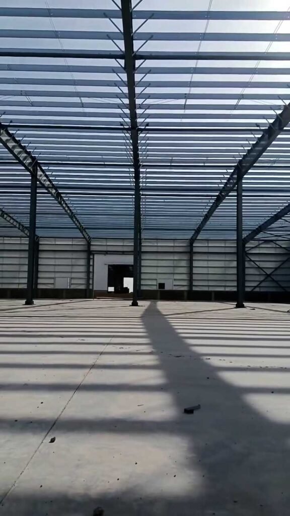 Clear-span industrial interior framed with high-strength Q355 steel columns for a smooth import steel warehouse assembly process.