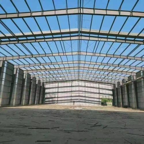 Looking up at galvanized roof purlins and Q355 steel rafters installed on a large-span project supplied by a leading industrial steel building exporter in China.