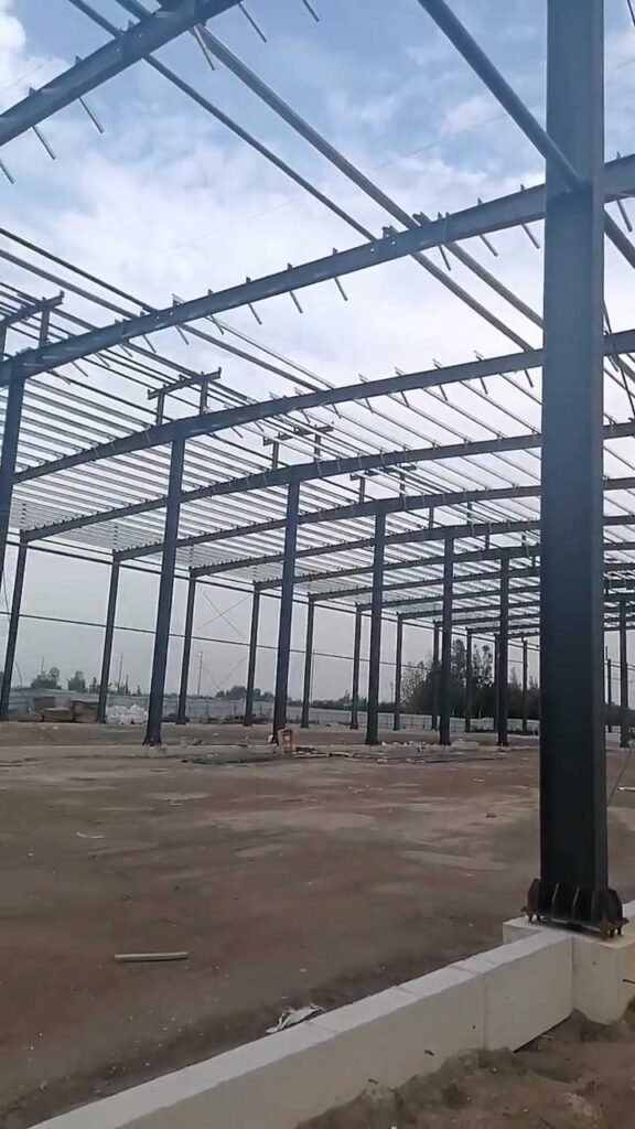 Structural steel framing including rigid columns and roof beams for an industrial steel building FOB project prior to wall panel installation.