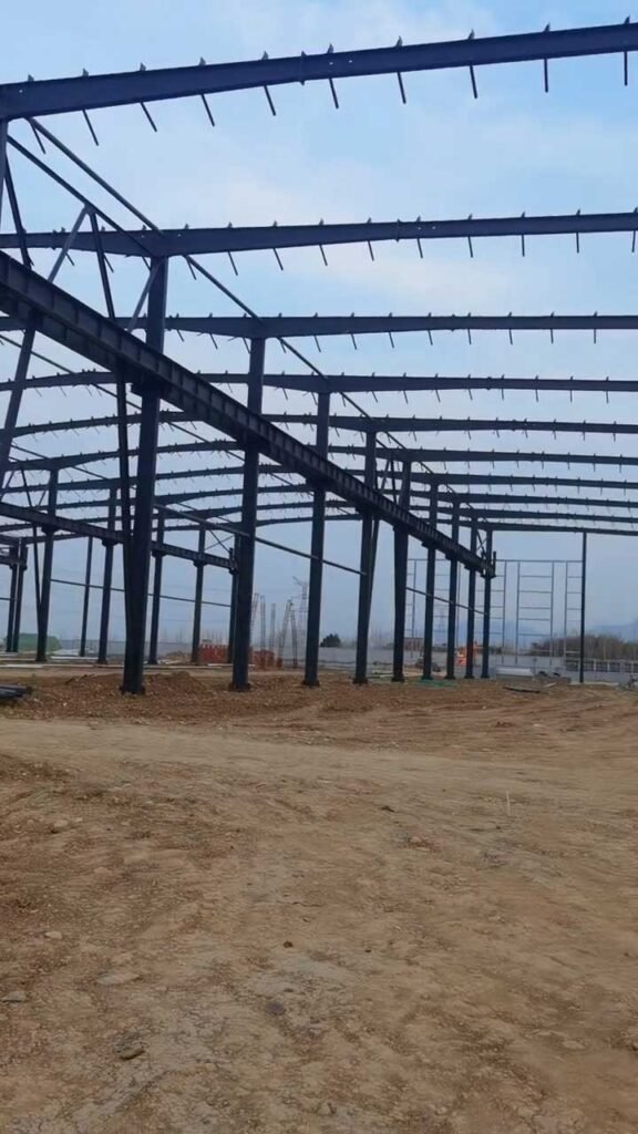 Installation of galvanized roof purlins and horizontal bracing systems on a heavy industrial warehouse steel building.