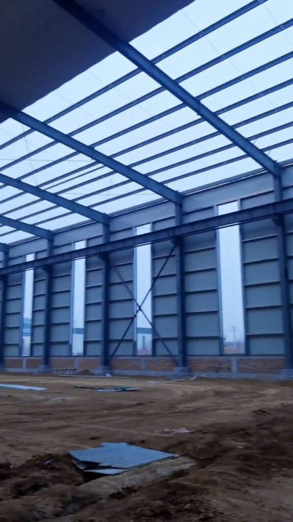 Detalle del muro de ladrillo perimetral de 1.2m y espacios para ventanas verticales en el diseño de almacenes logísticos.