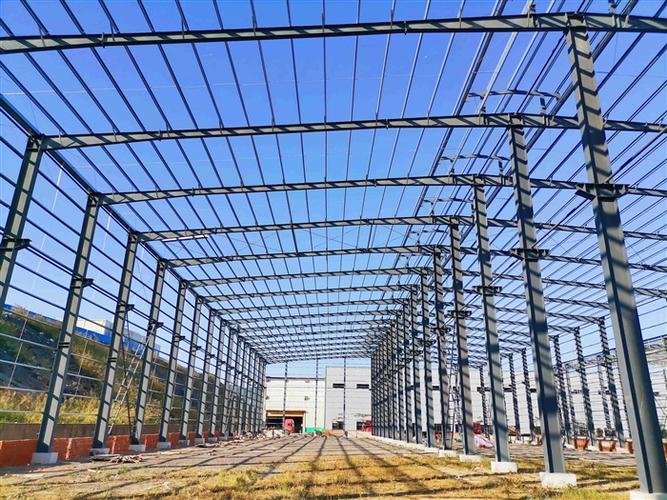Detailed view of Q355 structural steel columns, knee bracing, and rigid connections engineered by a professional prefabricated industrial building exporter.