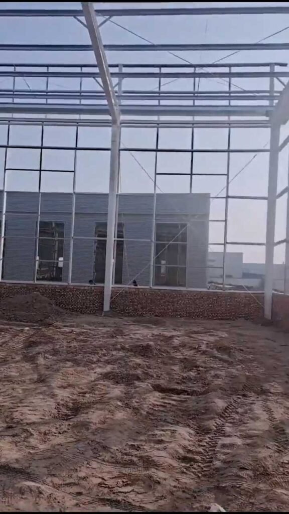 Detailed end-wall framing delivered by a direct steel building package supplier, highlighting the integration of rigid frames with large functional door and window openings.