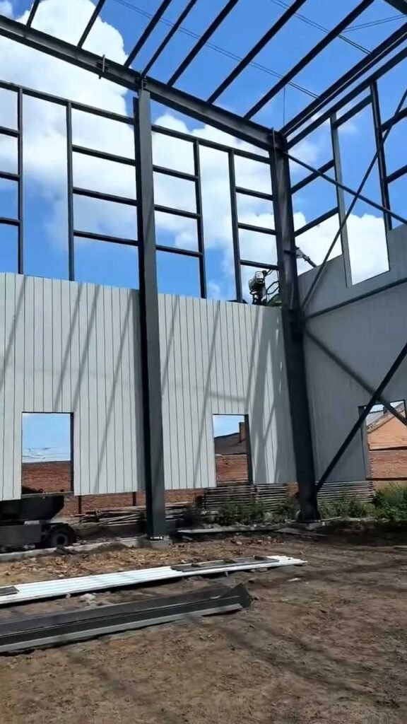 Exterior wall cladding panels being efficiently installed onto the structural frame, ensuring rapid project completion for a local steel building reseller.