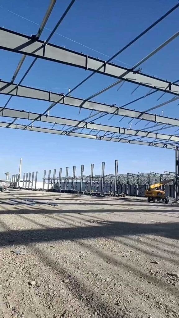 Wide view of structural steel columns and roof rafters processed and supplied by a certified steel fabrication company for a large-scale industrial project.