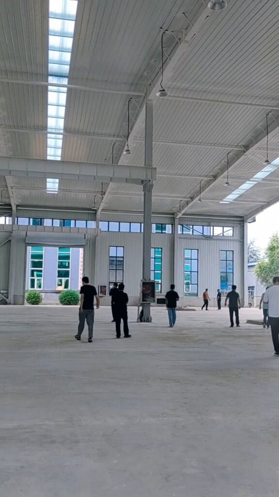 International buyers and engineers conducting an on-site structural inspection inside a completed industrial facility produced by our authentic steel warehouse factory.