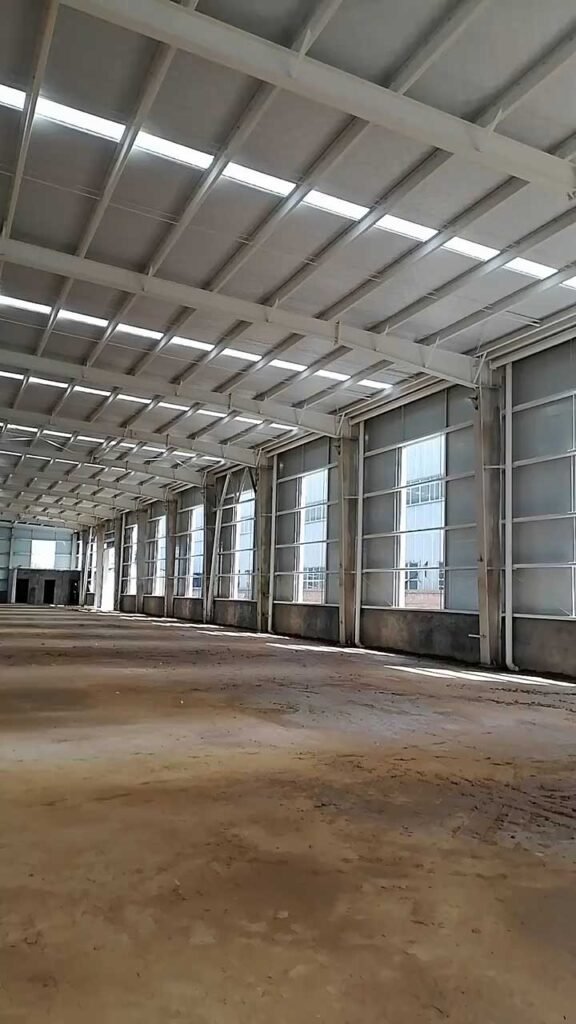 Detailed view of secondary framing and lateral wind bracing on a facility's side wall, essential structural elements driving the total steel warehouse project cost in high-wind regions.