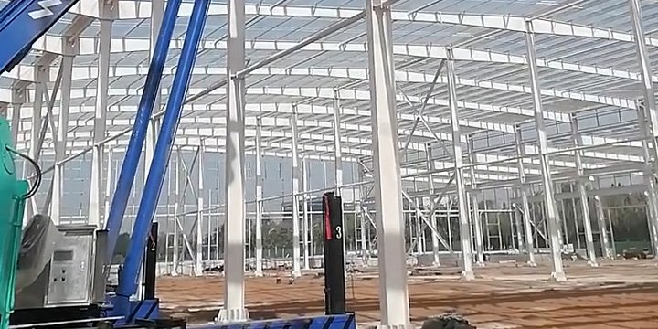Wide-angle view of a clear-span portal frame erected by a professional steel warehouse supplier, highlighting Q355 steel columns and rigid beam connections.
