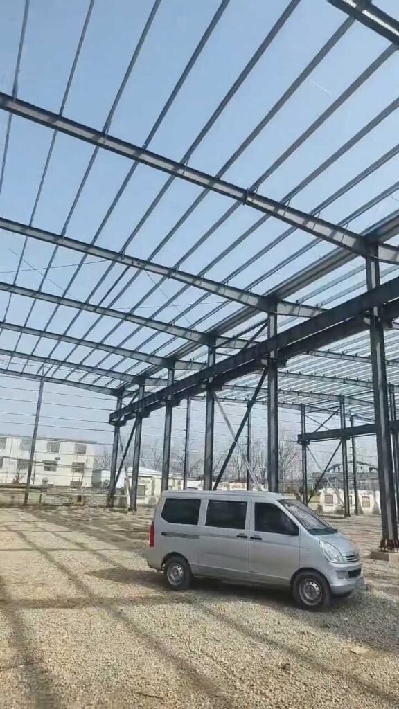 Espacio interior de gran luz libre sin columnas en la fase de montaje de un almacén de estructura metálica.