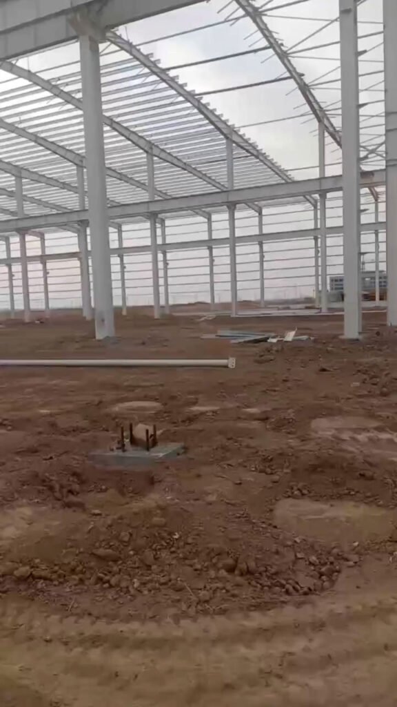 Detalle de pernos de anclaje en cimentación e interior de bodega industrial prefabricada de acero.