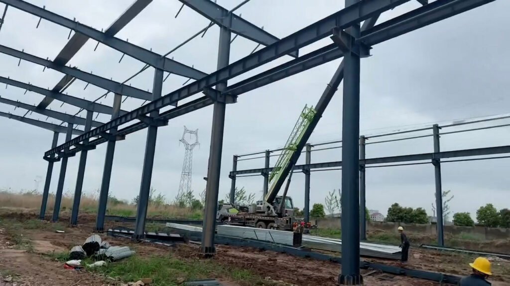 Montaje en obra con grúa de la estructura metálica para edificio industrial de acero.
