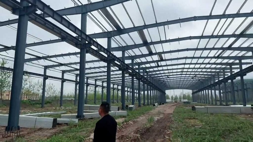 Pasillo interior despejado con luz libre en un edificio industrial de acero prefabricado.
