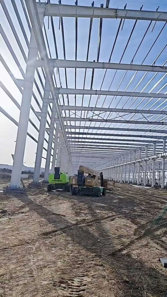 Instalación de vigas de cubierta y correas en un edificio industrial prefabricado mediante grúas de elevación