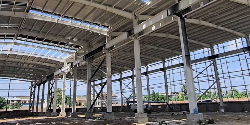 Arriostramientos transversales y pórticos estructurales instalados en la obra de un galpón prefabricado económico seguro.