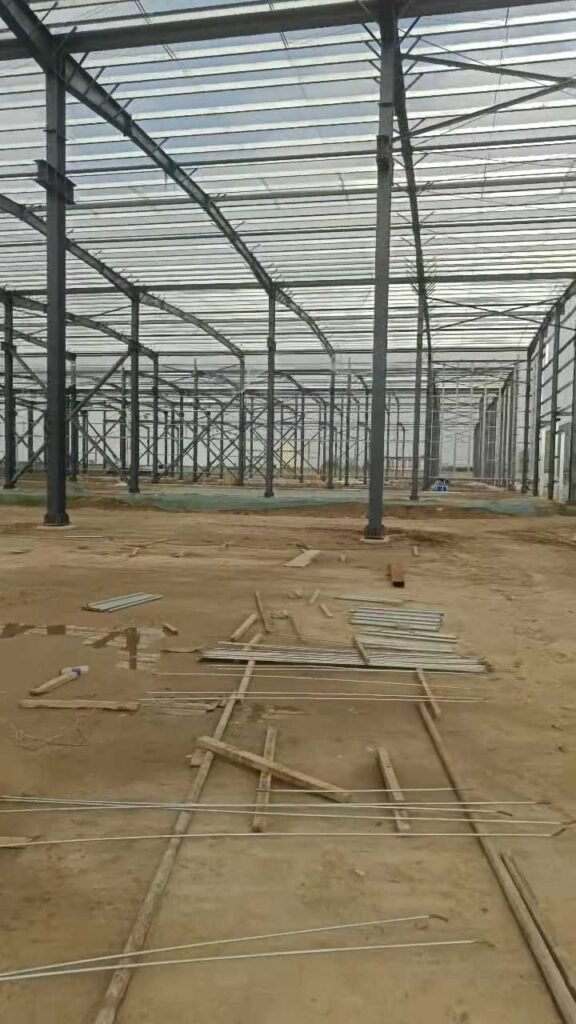 Montaje de la estructura metálica y cubierta de galpones chinos industriales en obra.