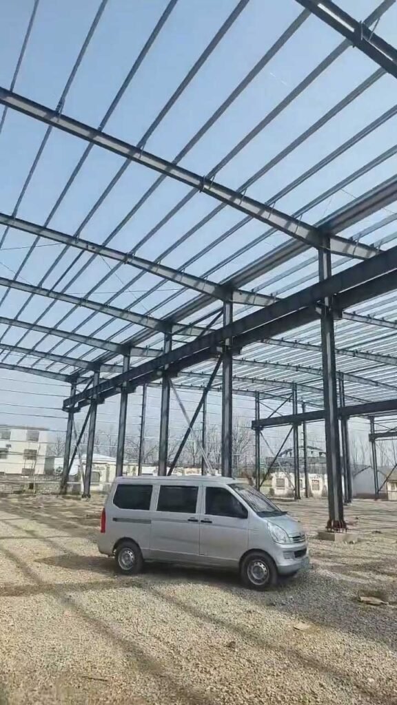 Pórticos rígidos y estructura secundaria de techo en la fase de montaje de un edificio prefabricado PEB para uso industrial.