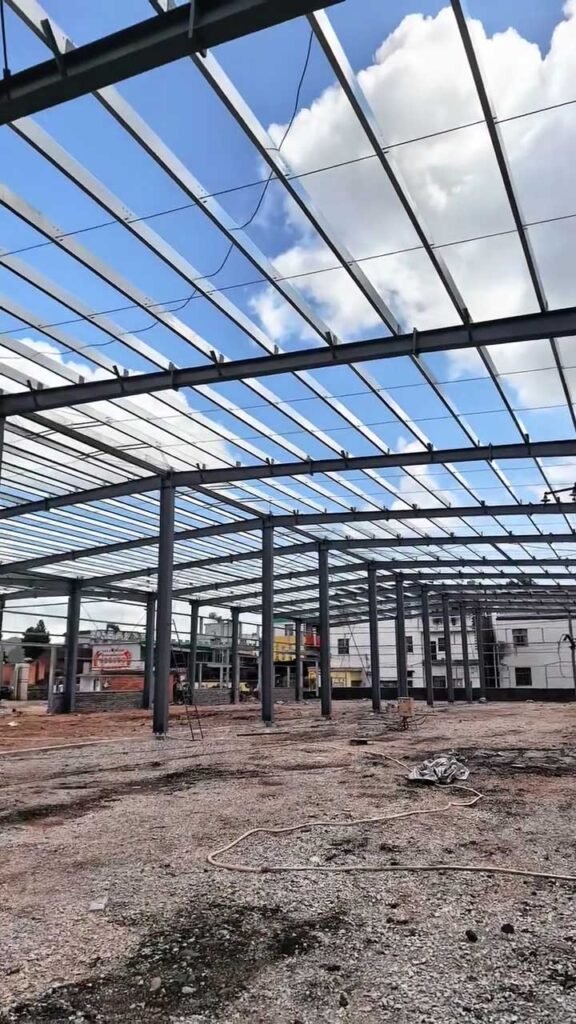 Avance de montaje de galpón prefabricado con perfiles H suministrados por proveedor de edificios metálicos.