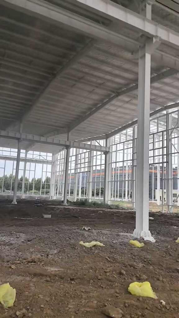 Pórticos de acero pintados y estructurados para un almacén metálico listo para cerramientos.