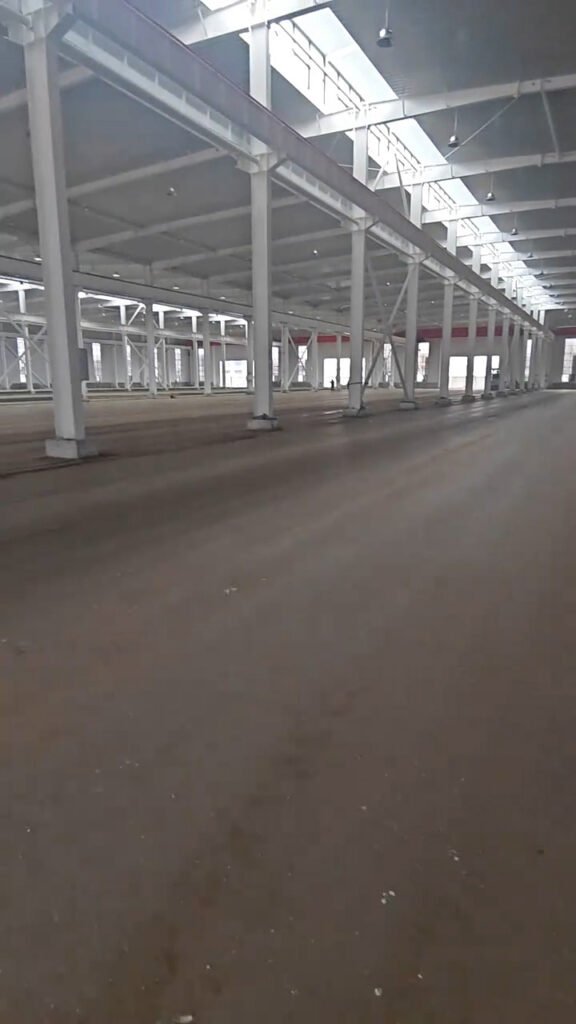 Vista de gran luz libre en bodega industrial con soporte de acero estructural por tonelada.
