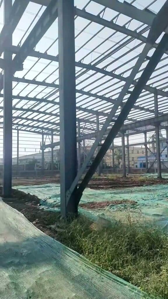 Detalle técnico de arriostramientos y conexiones en un edificio industrial prefabricado.