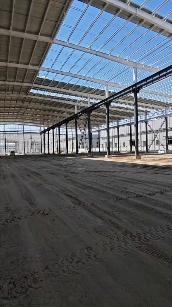 Iluminación natural y pórticos principales en bodega industrial prefabricada