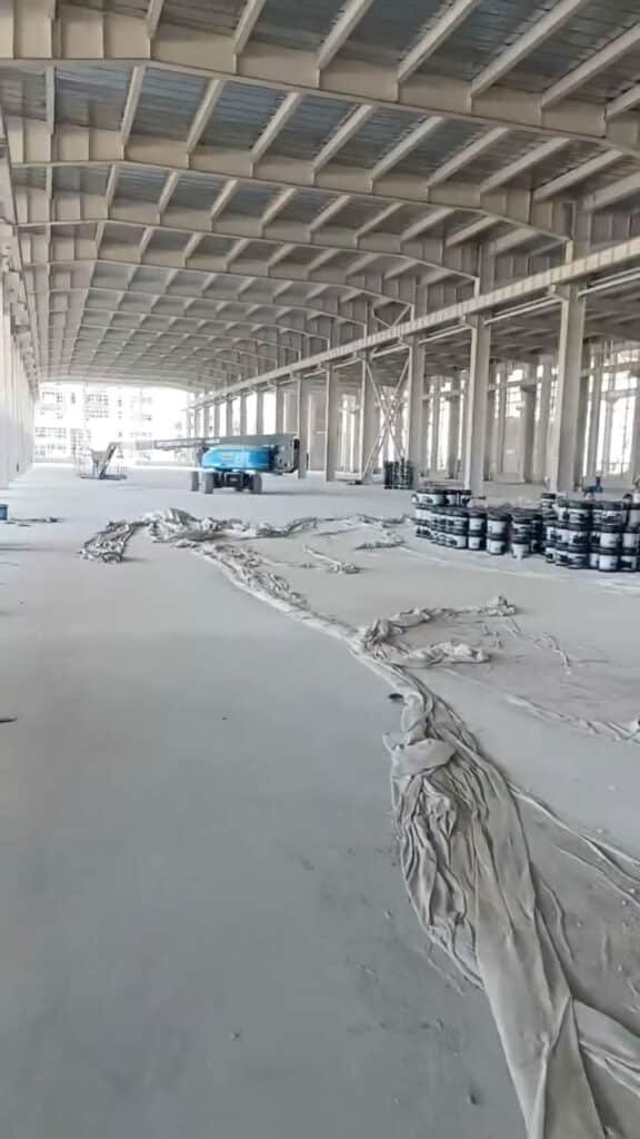 Plataforma elevadora azul instalando bodega metálica importada.