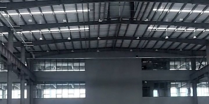 Trabajo de montaje en la construcción de bodegas con plataforma elevadora y pórticos de acero